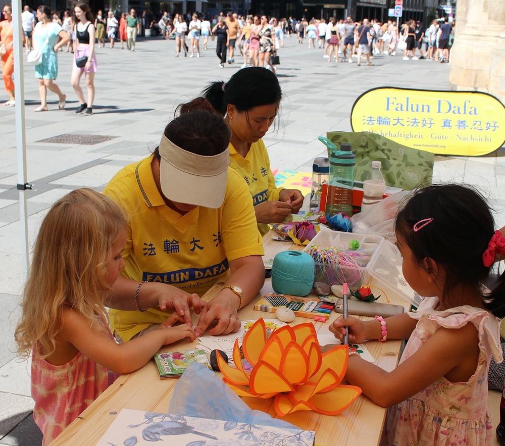 Falun-Gong-Praktizierenden zeigen interessierten Kindern das Lotusblumen basteln. Foto: FDI Österreich